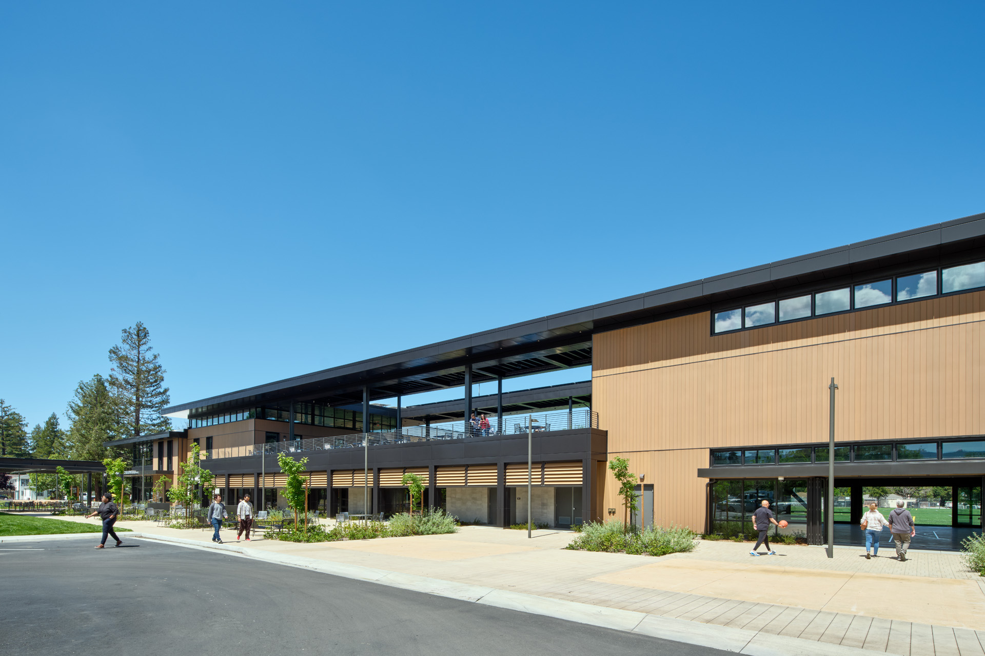 Building elevation showing continuous cladding, screening louvres and covered entry canopy